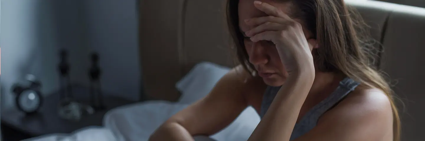 Frau legt verzweifelt Kopf in die Hand