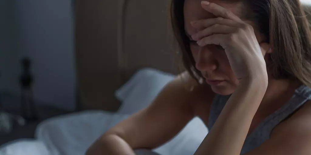 Frau legt verzweifelt Kopf in die Hand