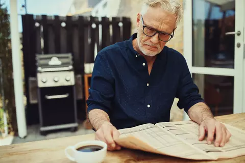 Älterer Herr liest in der Zeitung