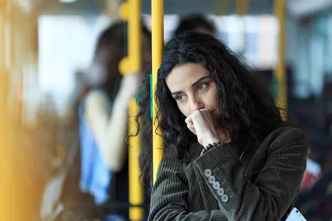 Frau steht nachdenklich im Bus