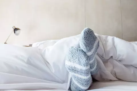 Kuschelsocken schauen unter Decke hervor