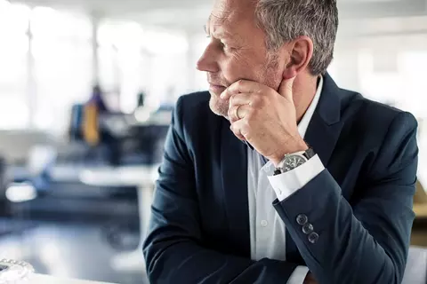 Mann sitzt nachdenklich am Tisch