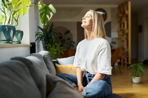 Frau im Schneidersitz vor dem Fenster