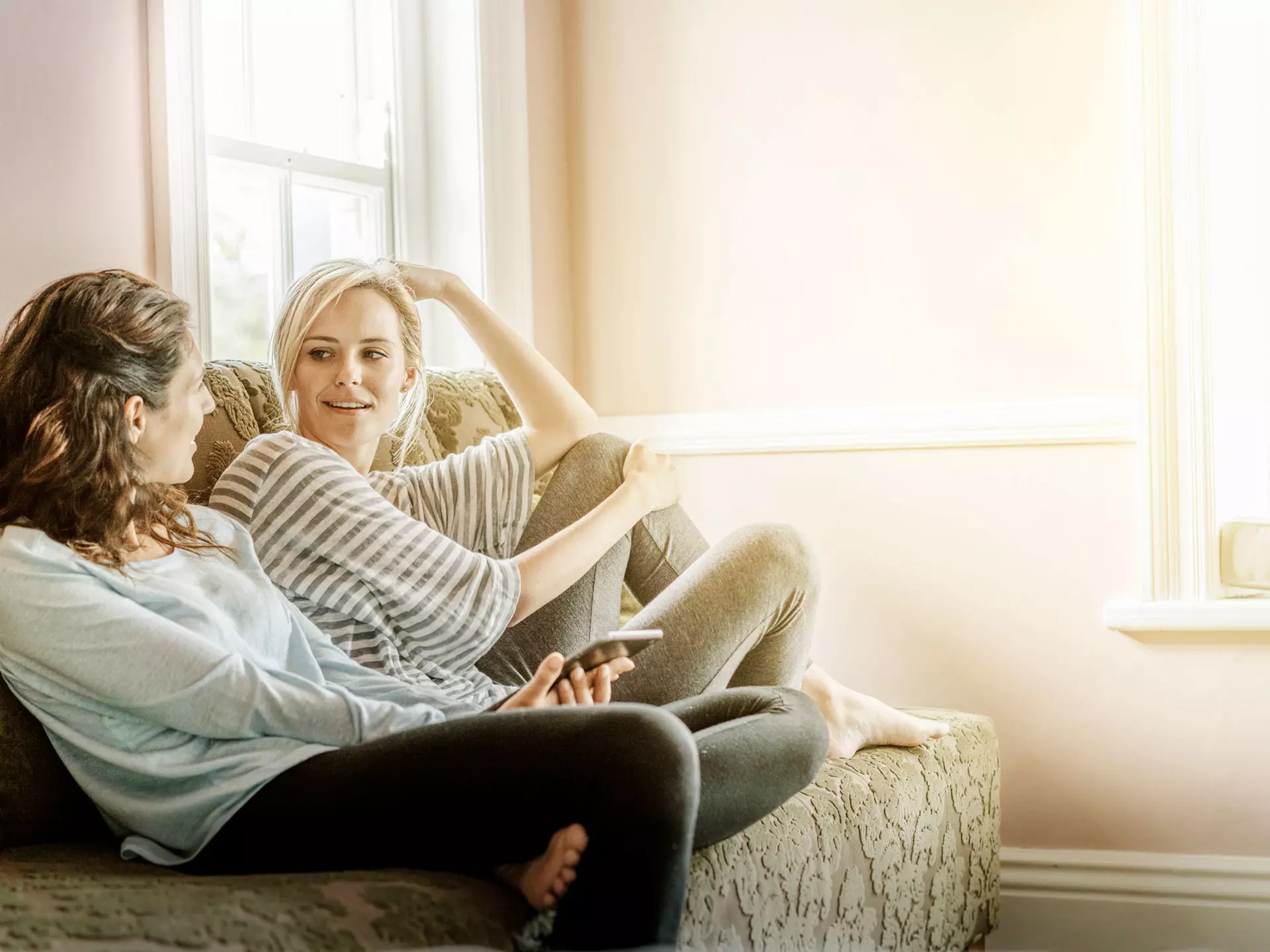 Freundinnen unterhalten sich auf dem Sofa 