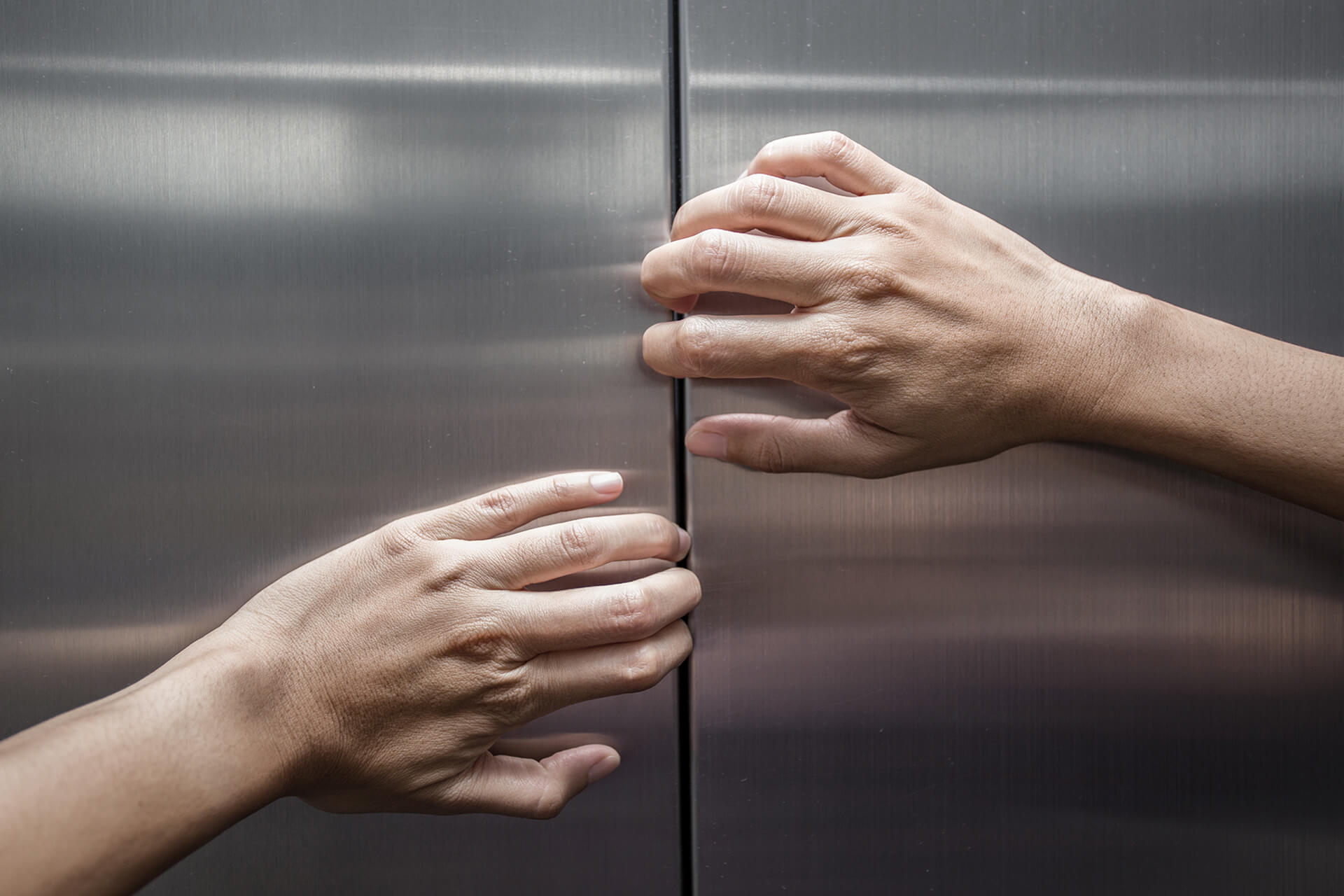Hände versuchen Aufzugstür zu öffnen
