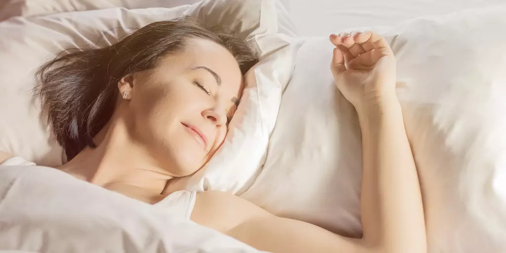Frau liegt entspannt im Bett