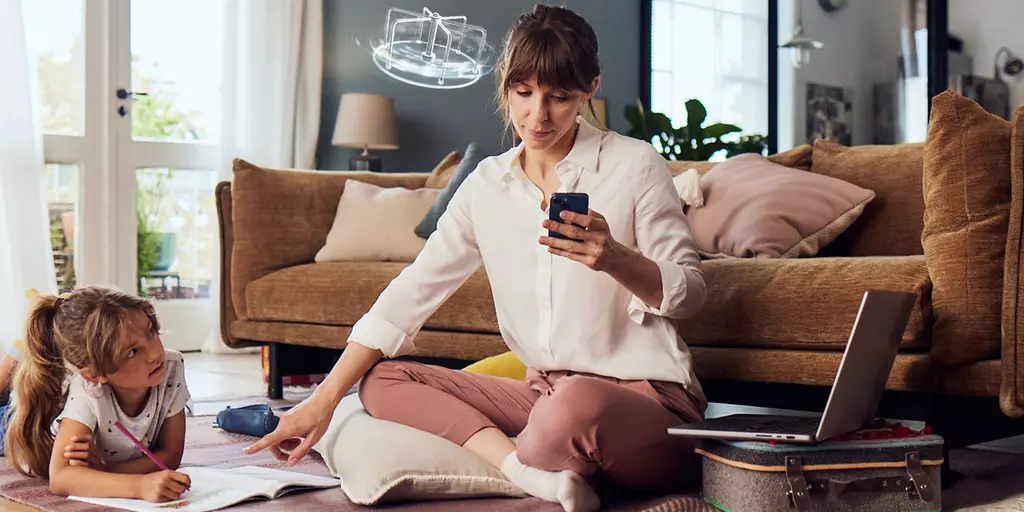 Mutter mit Kind im Wohnzimmer schaut gestresst auf ihr Handy