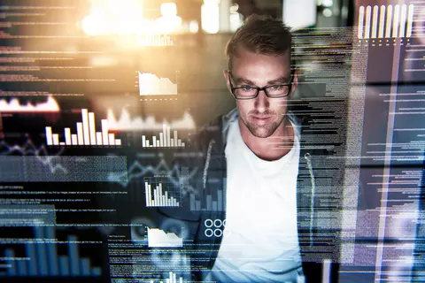 Mann mit fokussiertem Blick auf einen Bildschirm