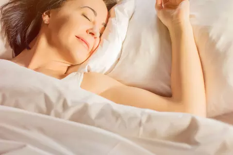 Frau liegt entspannt im Bett