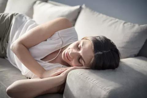 Frau schläft auf Sofa