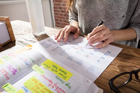 Frau schreibt in Kalender