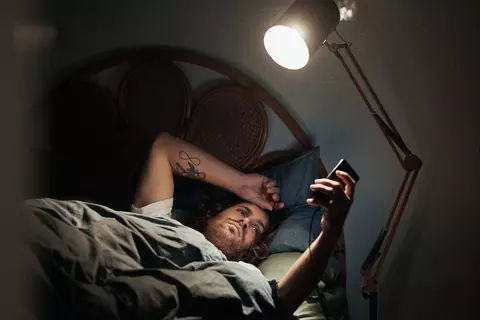 Mann schaut nachts ins Handy