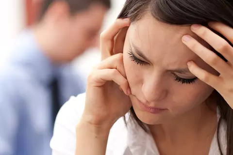 Junge Frau hält ihre Hände am Kopf
