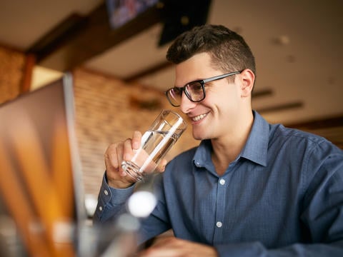 Mann trinkt Wasser und verzichtet auf alkoholische Getränke, um seine innere Unruhe loszuwerden.